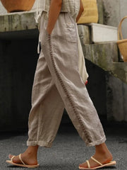 Khaki relaxed cropped pants with hollow out trim detail and pockets.