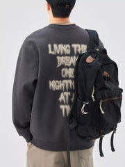 Oversized dark gray crew-neck sweatshirt with distressed graphic text on back.