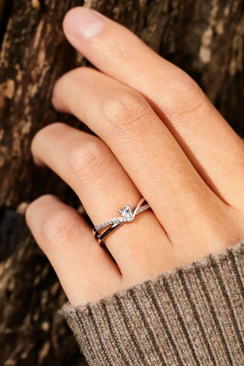 V-shaped silver ring with diamond accents and a central diamond.