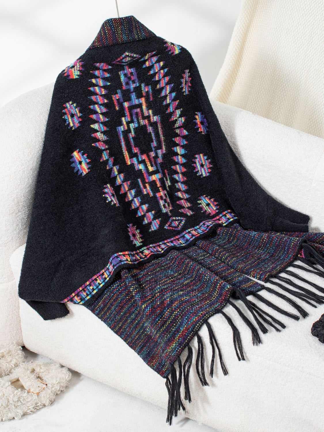 Black Aztec fringe knit cardigan with colorful geometric pattern and fringed hem.