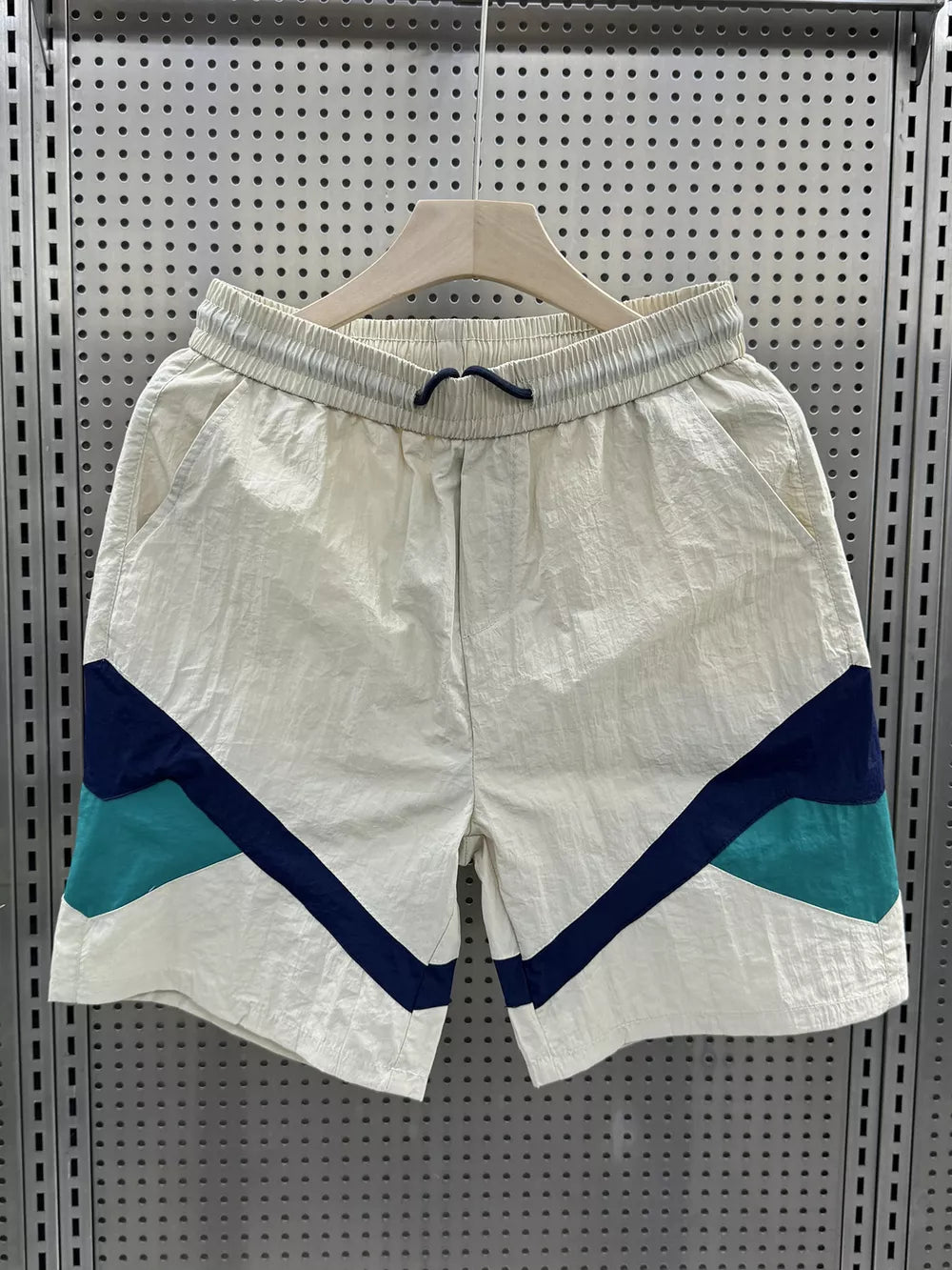 Men's beige boxer shorts with color block geometric pattern and drawstring waist.
