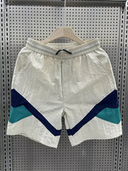 Men's beige boxer shorts with color block geometric pattern and drawstring waist.
