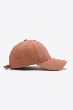 Rugged baseball cap in coral with distressed details and adjustable strap.
