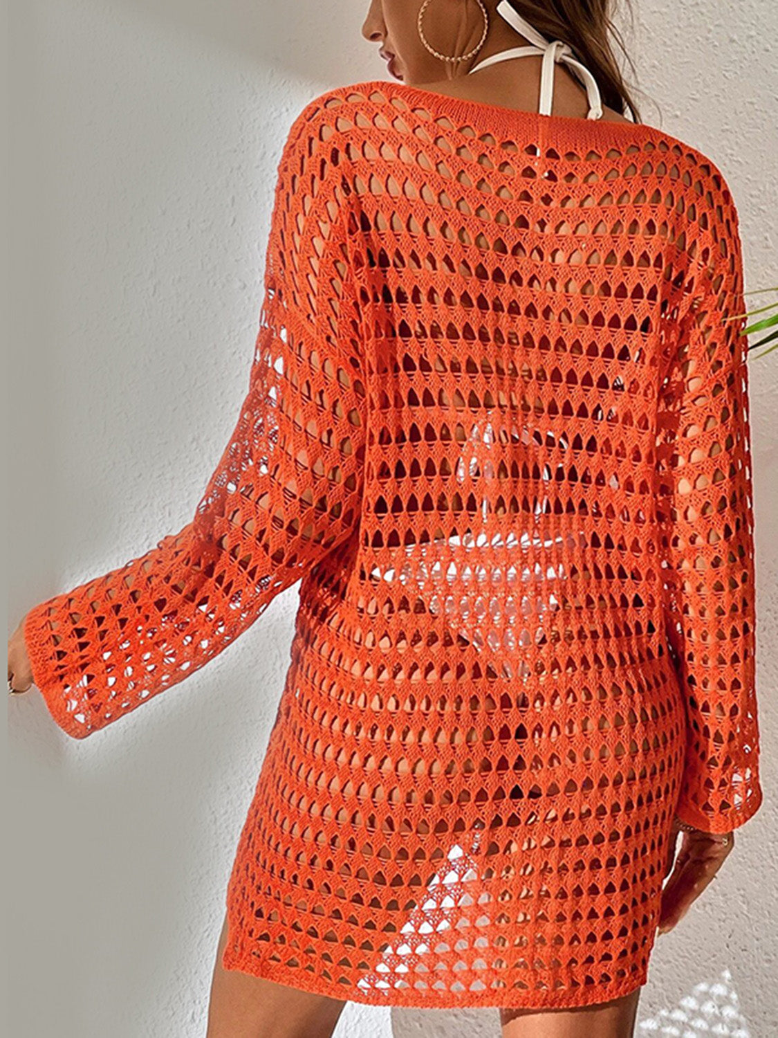 Orange open-knit beach dress with long sleeves and boatneck, styled over swimwear.