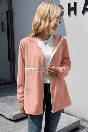 Blush pink hooded rain coat with white trim and zipper, casual lightweight jacket.