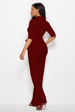 Burgundy belted palazzo jumpsuit with high neckline and three-quarter sleeves.