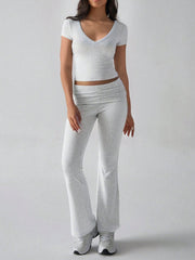 Light gray ribbed flare leg lounge set with v-neck crop top and ruched waistband pants.