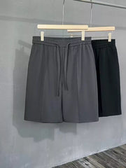 Men's dark gray pleated chino shorts with drawstring waist and pockets.