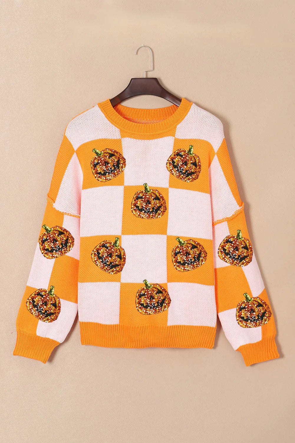 Checkerboard pumpkin appliqué knit sweater in tangerine with crew neck and long sleeves.
