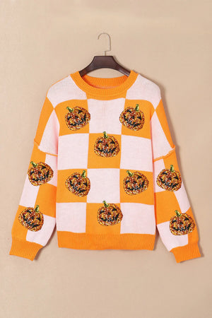 Checkerboard pumpkin appliqué knit sweater in tangerine with crew neck and long sleeves.
