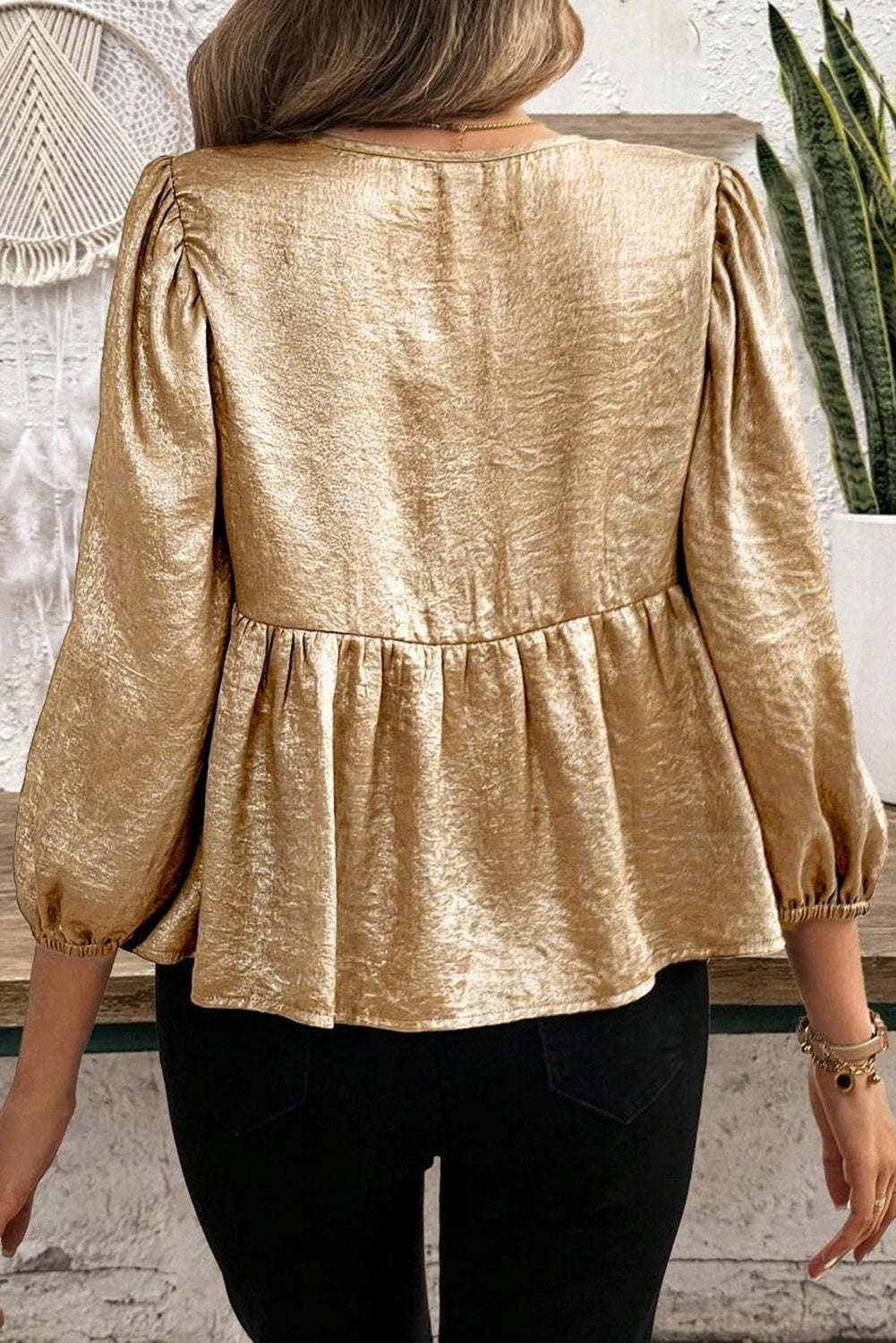 Gold peplum blouse with ruched sleeves and textured fabric.