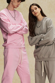 Oversized crewneck sweatshirt in blush pink and gray with subtle shoulders.