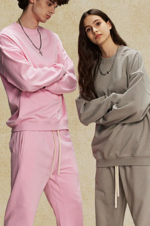 Oversized crewneck sweatshirt in blush pink and gray with subtle shoulders.