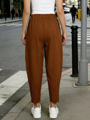 Caramel harem maternity joggers with vertical ribbing and pockets, styled with white sneakers.