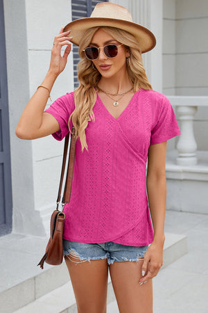 Eyelet wrap V-neck top in hot pink with short sleeves and a textured pattern.