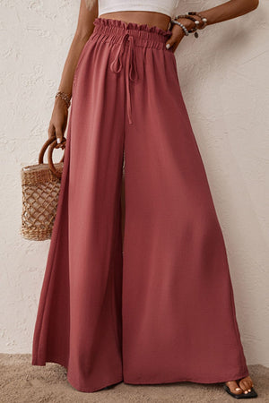 Crimson palazzo trousers with paperbag waist and drawstring, wide leg, and front slit.