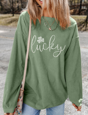 Sage corduroy sweatshirt with white beaded "lucky" and shamrock graphic.