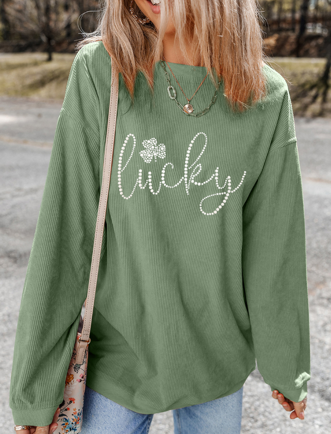 Sage corduroy sweatshirt with white beaded "lucky" and shamrock graphic.