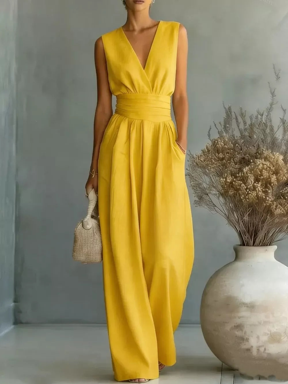 Yellow sleeveless wide-leg jumpsuit with V-neck, cinched waist, and pockets.