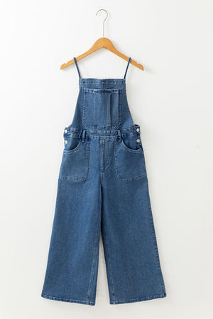 Denim wide-leg overalls in medium wash with adjustable straps and buttoned sides.