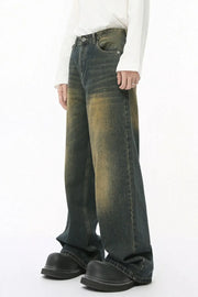 Faded wash balloon leg jeans in a distressed muddy denim color with a relaxed fit.