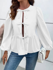 White peplum blouse with keyhole neckline and tie details, long puff sleeves.