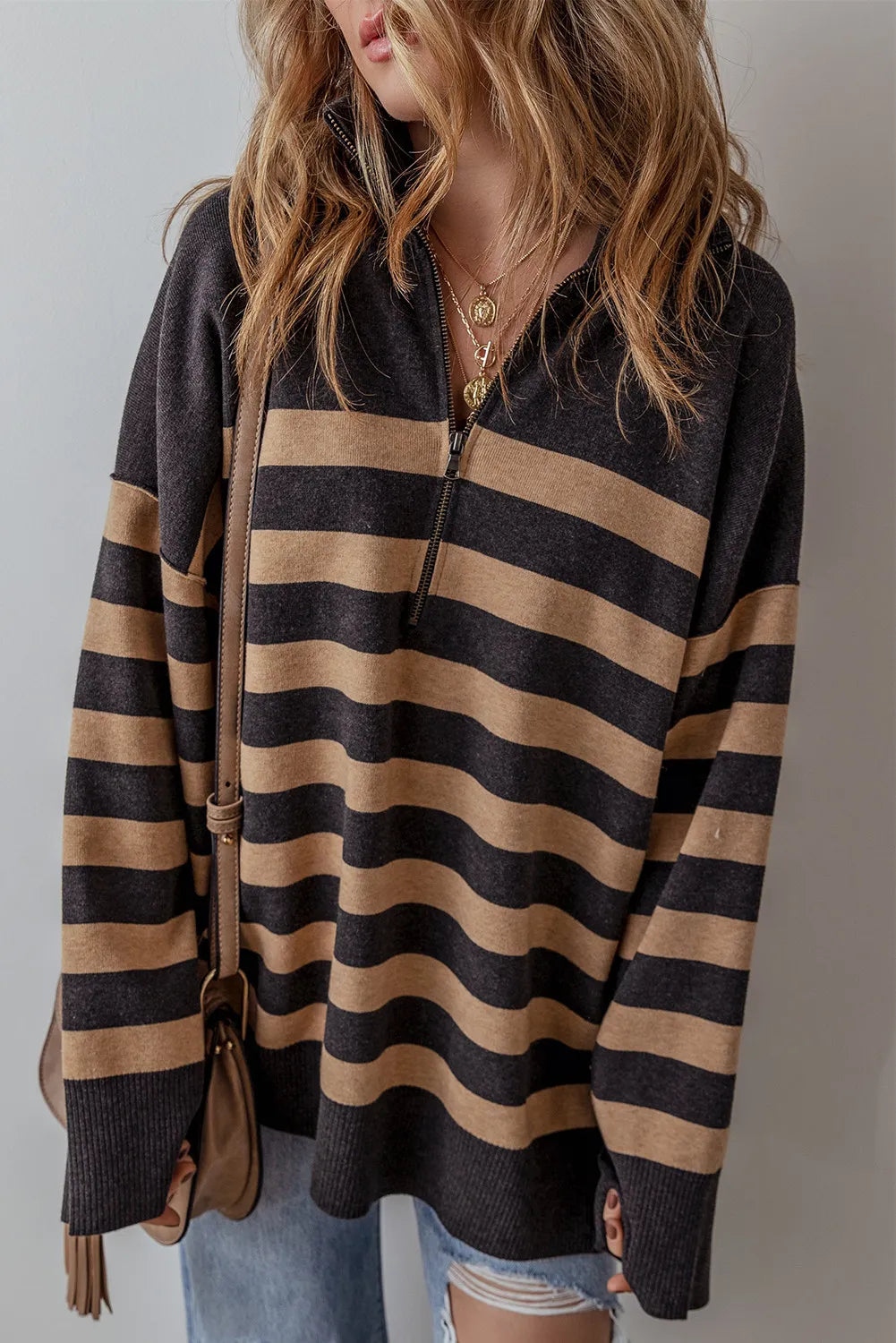 Oversized black and tan stripe knit pullover with half-zip neckline.
