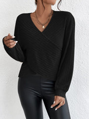 Black ribbed knit wrap top with blouson sleeves and V-neck.