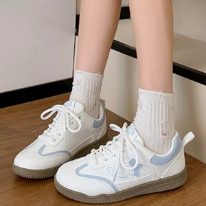 White lace-up sneakers with blue accents and cartoon details, casual women's shoes.