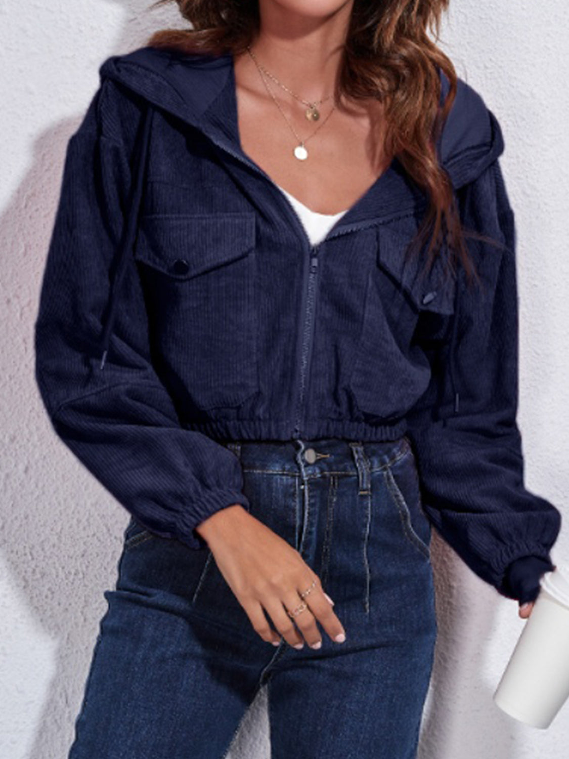 Dark blue corduroy hooded jacket with zip front, chest pockets, and elasticated cuffs.