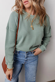 Relaxed sage waffle knit crewneck sweater with crew neckline and long sleeves.