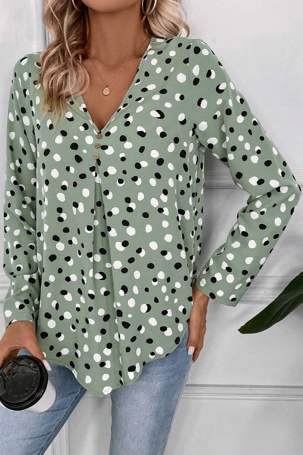Sage polka dot button-down blouse with V-neck and pleats.