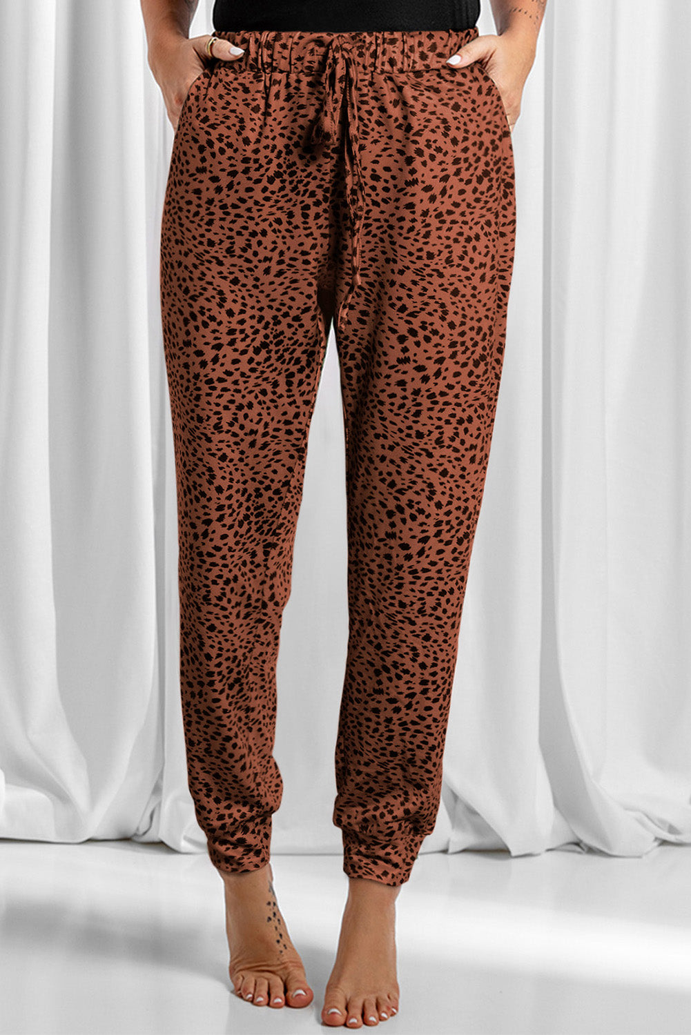 Brown leopard print jogger trousers with drawstring waist and cuffed ankles.