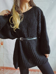Black oversized ribbed knit sweater with belted waist and long sleeves.