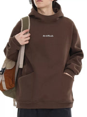 Oversized brown hoodie with subtle white text graphic and kangaroo pocket.
