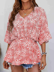 Women's scarlet abstract print cinched waist v-neck blouse with short sleeves.