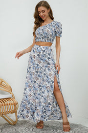 Floral one-shoulder crop top and high-slit maxi skirt set with blue and white floral print.