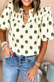 Textured polka dot blouse in matcha green with smocked yoke and ruffled neckline.