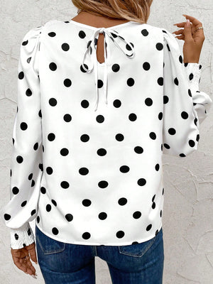 White polka dot blouse with smocked cuffs and back tie detail.