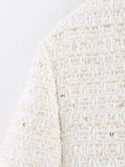 White tweed cropped jacket with gold sequins and button-up detail.