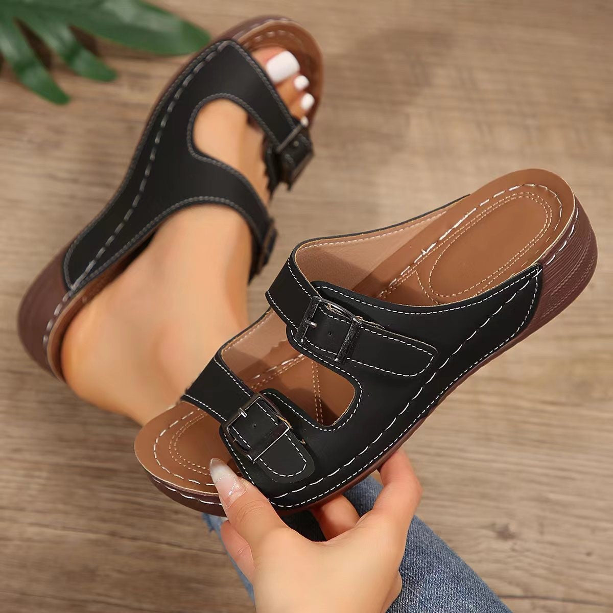 Black dual buckle mid-wedge sandals with adjustable straps and white contrast stitching.