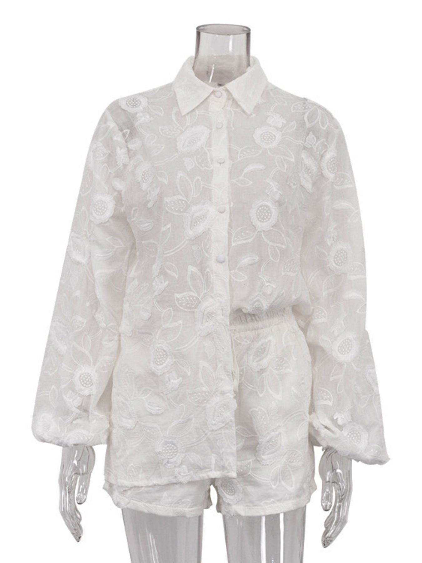 White embroidered two-piece shirt and shorts set with button-down shirt and elastic waist shorts.