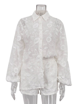 White embroidered two-piece shirt and shorts set with button-down shirt and elastic waist shorts.