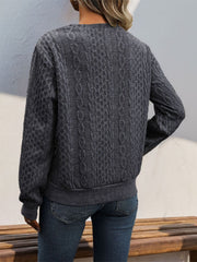 Dark gray cable knit sweater with asymmetric button-neck detail and ribbed cuffs and hem.
