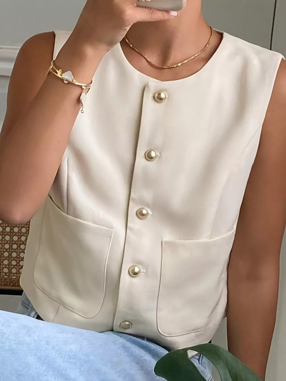 Cream button-down sleeveless vest with crew neck and patch pockets.