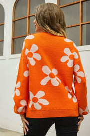 Orange acrylic sweater with white daisy intarsia pattern, crew neck, long sleeves.