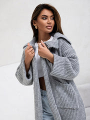 Oversized gray knit cardigan with lapel neckline and pockets, styled casually.
