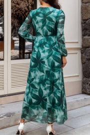V-neck wrap maxi dress in green botanical print, long sleeves, elastic waist, flowy skirt.