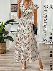 Floral print midi dress with cap sleeves and a V-neck in apricot with black abstract pattern.