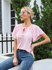 Blush pink perforated tie-neck blouse with flutter sleeves and eyelet details.
